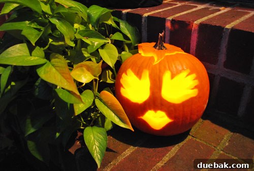 The finished handprint pumpkin glowing with a flameless candle