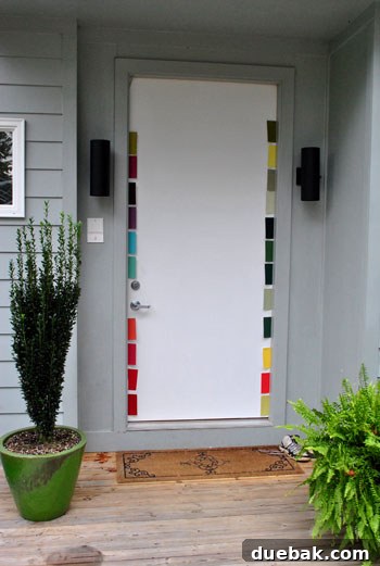 Close-up of various paint swatches held against the gray house and plain door