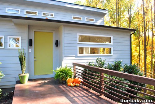 Emily's freshly painted green door and stained deck, showcasing the completed makeover