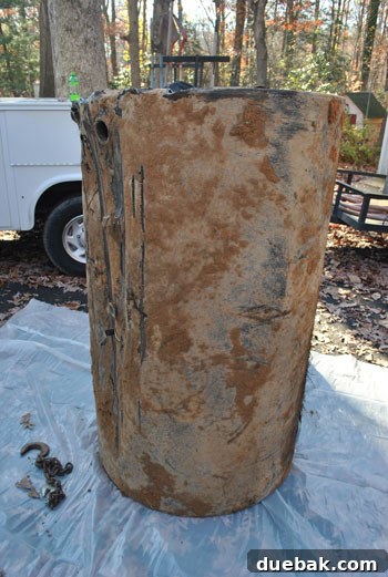 Old, heavily rusted underground oil tank after excavation