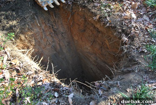 Large excavation pit in a residential yard for oil tank removal and soil remediation