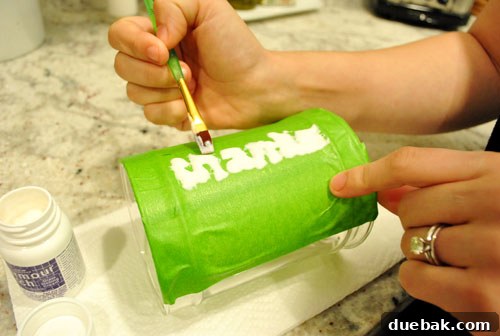 Applying glass etch cream to the side of glass apothecary jar for Thanksgiving craft