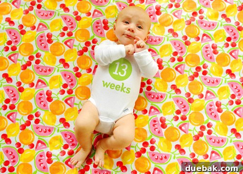 Baby Clara with a mischievous smirk, as if twirling an invisible mustache, during her weekly photo