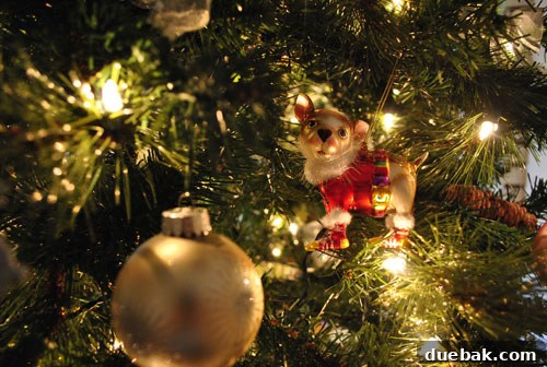 Our Kaleidoscope Christmas Tree 5 Close-up of a whimsical chihuahua ornament with a festive sweater hanging on the Christmas tree.