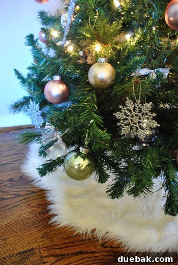 Our Kaleidoscope Christmas Tree 8 The base of the Christmas tree, featuring faux sheepskin rugs used as a tree skirt, with ornaments visible above.