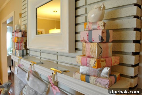 A selection of pink and silver wrapping paper, ribbons, and empty gift boxes for DIY holiday decor.