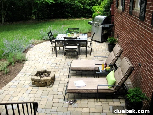 Loose Threads 5 A beautifully furnished outdoor patio with a comfortable seating arrangement, throw pillows, and potted plants, inviting relaxation