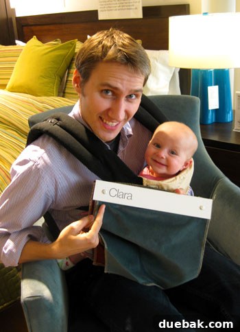 John and Clara relaxing in the Clara chair at Crate & Barrel, showcasing comfort and style.
