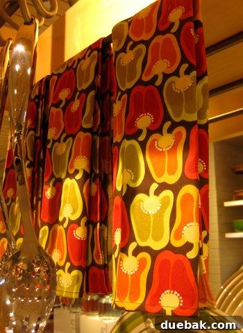 Pepper-patterned dishtowels, a vibrant and practical kitchen gift for those with red or green accents.