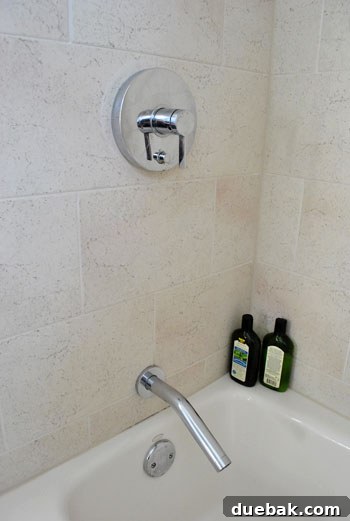Close-up of sleek, modern stainless steel shower fixtures in a renovated bathroom