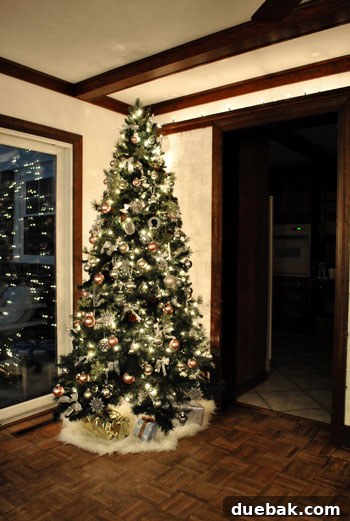 Decking Our New Home for Christmas 2 A beautifully decorated Christmas tree, aglow with warm lights and ornaments, stands proudly in the corner of a new living room, signifying the start of holiday traditions.