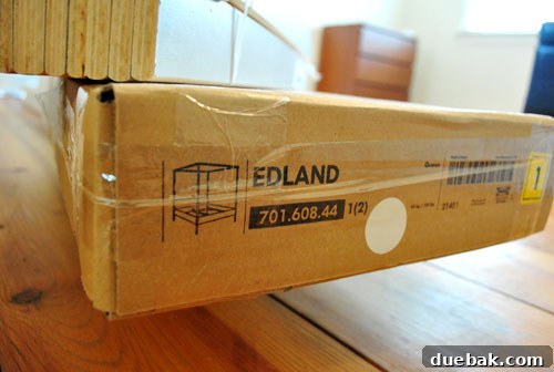 Unassembled IKEA Edland four-poster bed frame components