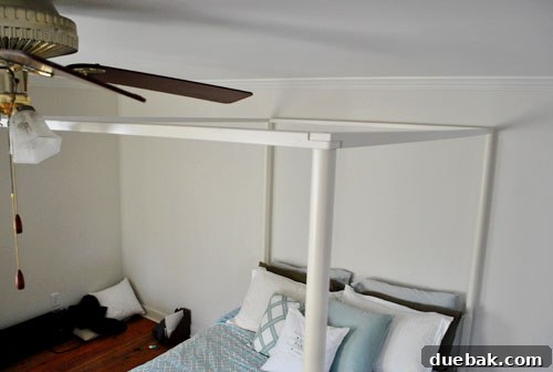 Close-up of the four-poster bed showing clearance with a ceiling fan