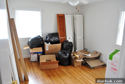 Cluttered guest room serving as storage for various boxes and household items