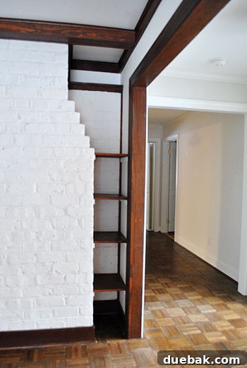 Before image of a fireplace corner with built-in wooden shelves