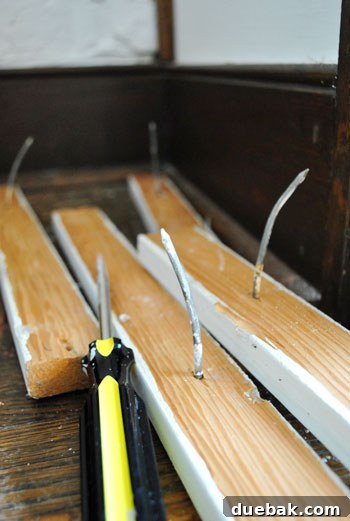 Close-up of stubborn shelf supports after wooden shelves removed, highlighting difficulty