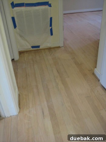 Furniture and boxes crammed into a room to protect them during professional hardwood floor refinishing, illustrating major home disruption.