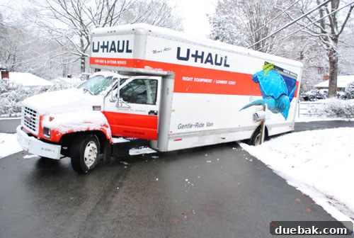 U-Haul truck stuck in a ditch on the side of the road, showing a stressful and unexpected setback on moving day.