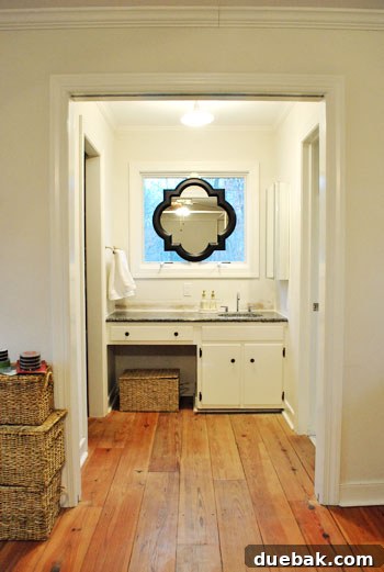 Close-up view of the bathroom mirror in its previous state, showing a darker frame