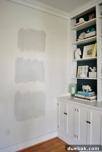 test areas of three Benjamin Moore gray paint colors applies to an area of white wall
