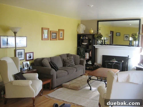 After photo of a newly painted white fireplace mantle with crown moldings and a large mirror with a dark ebony wood frame