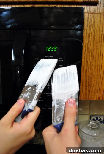 Breathing New Life Into Our Living Room Trim 5 Two paintbrushes propped up, 'toasting' in front of a microwave clock displaying the late hour