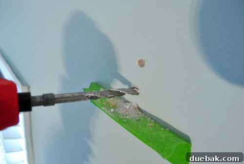 Dust-Free Drilling with Painter's Tape 3 Close-up view of a painter's tape shelf on a wall, successfully collecting a significant amount of drywall dust during drilling.