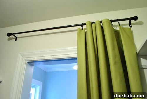 Interior view of the closet curtain rod placement, showing it high and wide for functionality
