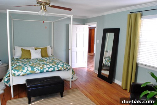 Bedroom view showing the new yellow-green curtains, bedding, and pillows