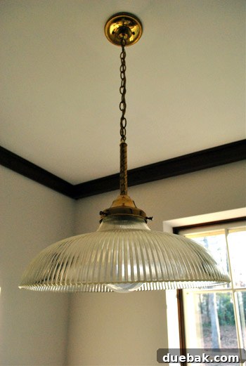 Original brass and glass pendant light in the corner of a living room, highlighting its initial design.