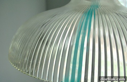 Close-up view of the glass light shade from the outside, showing the subtle and diffused turquoise tint after the interior has been painted.