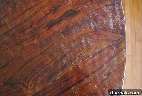 Close-up of the Stella dining table's hand-carved sheesham wood top, showcasing its unique texture.