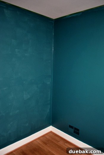 Comparison of guest room walls: one with single coat, one with two coats of dark teal paint.