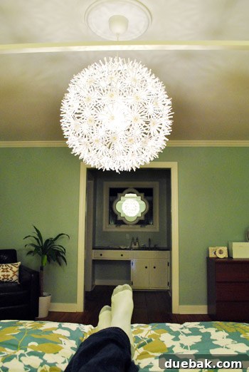 View of the bedroom from the bed, showing the Maskros lamp reflected in a mirror