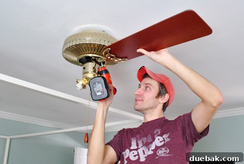 Ceiling fan motor removed from the ceiling, wires exposed