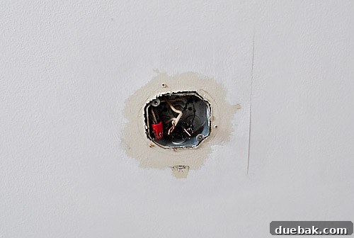Close-up of the ceiling after fan removal, showing unfinished paint and a patch