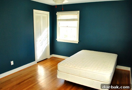 The guest room in its initial, sparse state, featuring bare walls and minimal furniture, before the significant decor and comfort upgrades.