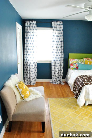 Close-up view of the guest room's green upholstered headboard and mixed patterned bedding, reflecting a personalized and cozy style.