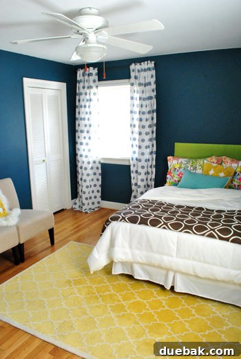 Detail of the guest room bedding, showing a layered mix of white, brown, yellow, and blue textiles from various retailers, creating an eclectic yet coordinated look.