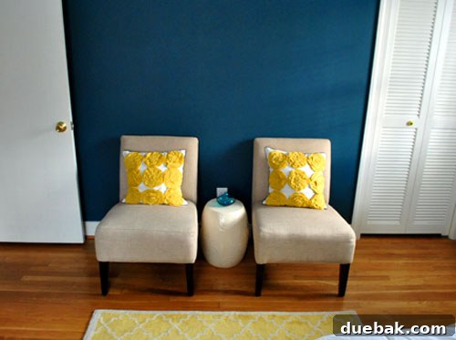 Guest room seating area with ceramic stool and cellphone charging spot