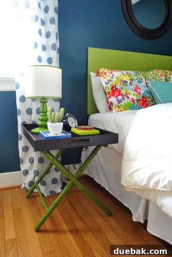 DIY luggage rack side table with green lamp next to guest bed
