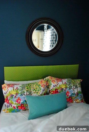 Oil-rubbed bronze mirror hanging above the guest bed
