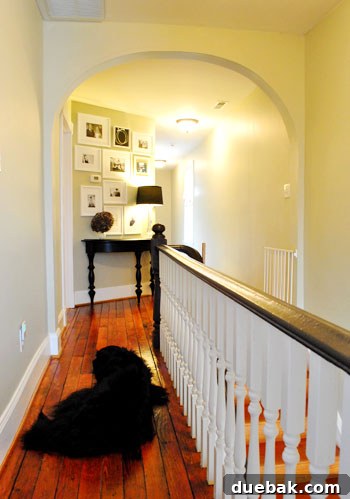 Upstairs diagonal wall with a cabinet and framed family mementos