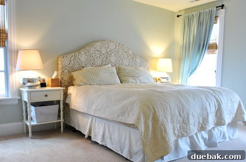 Master bedroom with patterned headboard and gray-blue curtains