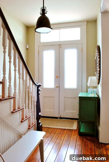 Stylish entryway nook with green cabinet and refurbished mirror