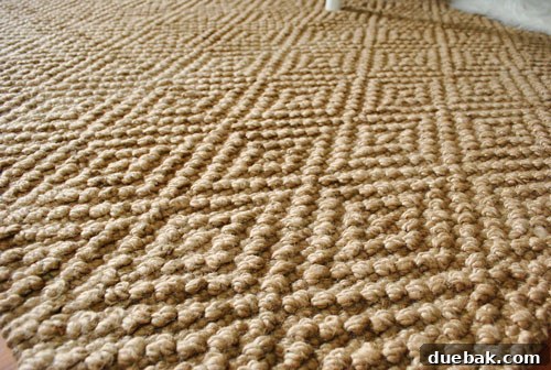 Close-up detail of the jute rug, showcasing its soft texture and subtle diamond weave.