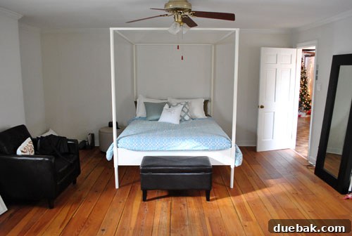 Bedroom view before renovation, featuring a Christmas tree and older decor, highlighting the previous design.