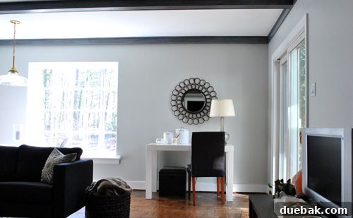 The Desk's Reflective Orbit 2 Ornate oil-rubbed bronze round mirror on a large living room wall, poised for a style transformation.