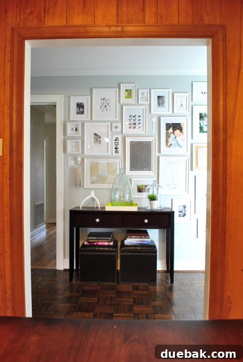 View of the completed hallway gallery wall from the kitchen, with a console table