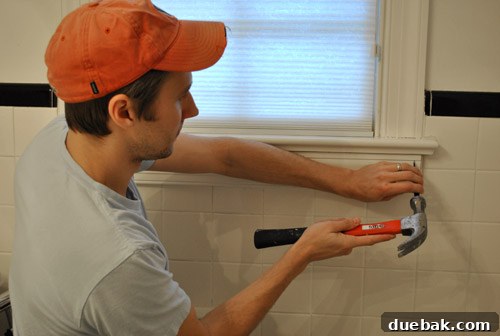 Clever Trim Tricks for Damaged Tiles 7 Installing new custom-cut window trim with finish nails and nail punch